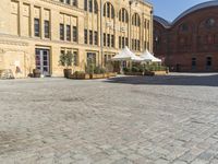 there is a large building in the center of the courtyard with a sidewalk attached to it