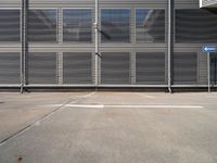 an empty parking lot with metal roller shutter doors and a stop sign on the corner