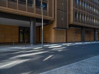 a road through which is a large modern building with an awning over it's entrance