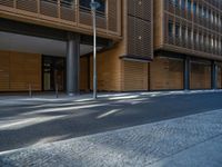 a road through which is a large modern building with an awning over it's entrance