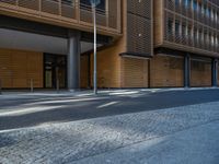 a road through which is a large modern building with an awning over it's entrance