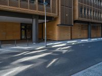 a road through which is a large modern building with an awning over it's entrance