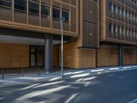 a road through which is a large modern building with an awning over it's entrance