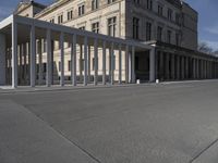 a building is shown with several columns surrounding it and a sign above it on the sidewalk