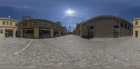 fish eye view of several buildings and cobblestone streets in front of it and an umbrella on the roof