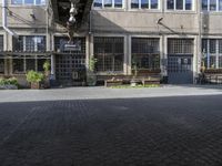 an empty parking lot in an urban area with windows and benches to sit and relax on