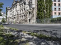 a person is riding a bike on the side of the road next to a large building