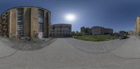 360 - view image of urban buildings with parked cars in the distance, with the sun in the sky behind them