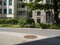 the yellow fire hydrant is located on the corner of this square of paved stones