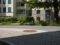 the yellow fire hydrant is located on the corner of this square of paved stones