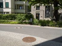 the yellow fire hydrant is located on the corner of this square of paved stones