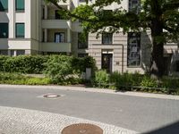 the yellow fire hydrant is located on the corner of this square of paved stones