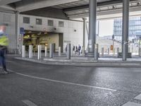 a man on a skateboard rides past the entrance to an airport parking garage with many poles and barriers