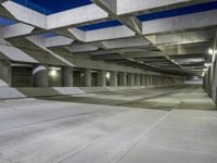 an empty parking garage with no people in it at night time time with only one stop sign