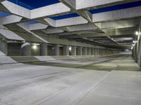 an empty parking garage with no people in it at night time time with only one stop sign