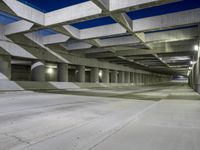 an empty parking garage with no people in it at night time time with only one stop sign