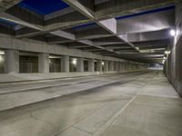 an empty parking garage with no people in it at night time time with only one stop sign