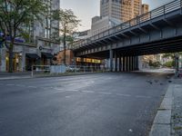 a city street that has a bridge over the road at sunset on a clear day