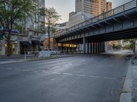 a city street that has a bridge over the road at sunset on a clear day