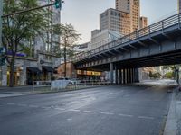 a city street that has a bridge over the road at sunset on a clear day