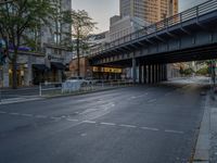 a city street that has a bridge over the road at sunset on a clear day