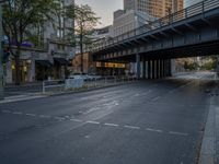 a city street that has a bridge over the road at sunset on a clear day