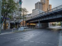 a city street that has a bridge over the road at sunset on a clear day