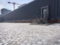 a brick building with glass windows and sidewalk leading to it and a black fire hydrant