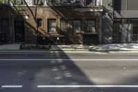 a street has a line painted on the curb and cars are parked on it in front of brick buildings