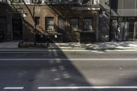 a street has a line painted on the curb and cars are parked on it in front of brick buildings