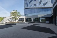 a view of an outside area of an office building with large windows and a circular driveway