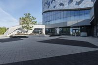 a view of an outside area of an office building with large windows and a circular driveway