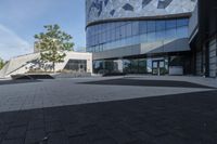 a view of an outside area of an office building with large windows and a circular driveway