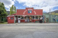 a building that has an old gas station in it's center road with a few trees in the background