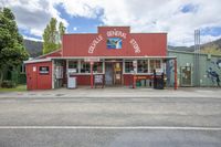 a building that has an old gas station in it's center road with a few trees in the background