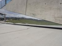 a skateboarder is riding on the sidewalk by the building of an art museum
