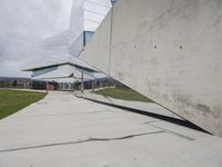 a skateboarder is riding on the sidewalk by the building of an art museum