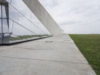 a skateboarder is riding on the sidewalk by the building of an art museum