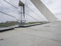 a skateboarder is riding on the sidewalk by the building of an art museum