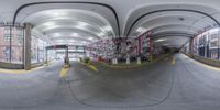 a very wide angle view of the inside of an urban building with graffiti on the walls