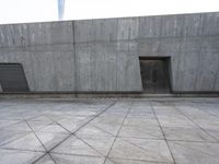 a large gray building with some concrete walls and a closed door in it's center