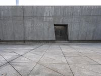 a large gray building with some concrete walls and a closed door in it's center