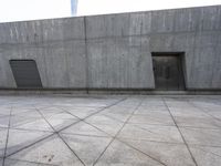 a large gray building with some concrete walls and a closed door in it's center