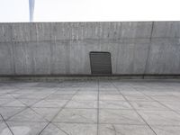 a large gray building with some concrete walls and a closed door in it's center