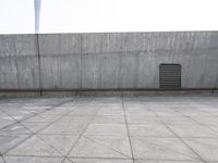 a large gray building with some concrete walls and a closed door in it's center