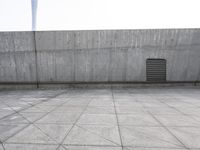 a large gray building with some concrete walls and a closed door in it's center