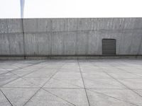 a large gray building with some concrete walls and a closed door in it's center