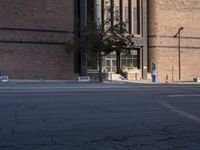 a parking meter at a street corner is in the foreground of an urban building