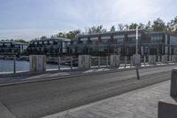 an apartment complex with an overpass and a bike park area behind it on an asphalt road