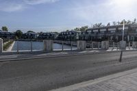 an apartment complex with an overpass and a bike park area behind it on an asphalt road